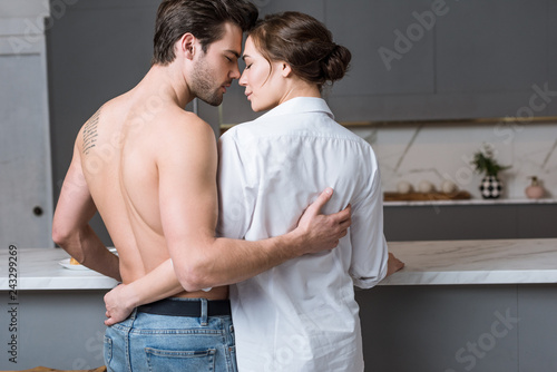 adult man and woman embracing at home with closed eyes