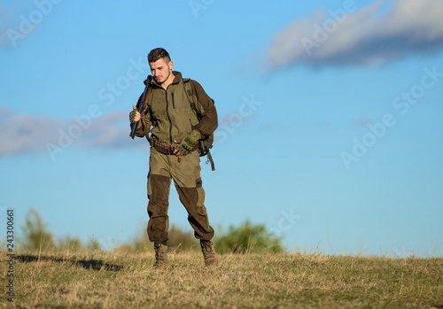 Guy hunting nature environment. Masculine hobby activity. Hunting weapon gun or rifle. Man hunter carry rifle blue sky background. Experience and practice lends success hunting. Hunting hobby