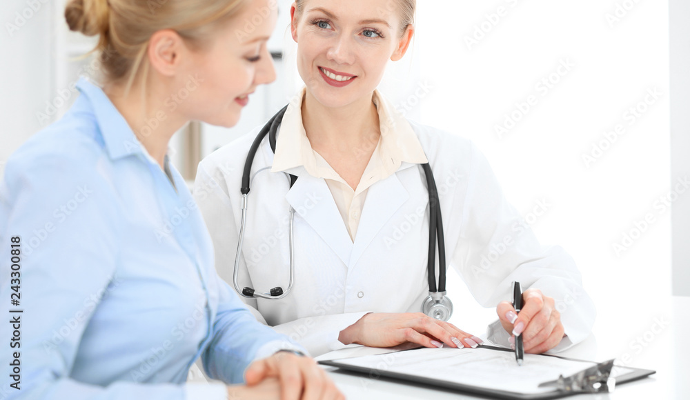 Doctor and patient talking in hospital office while sitting at the desk. Health care and client service in medicine Doctor and patient talking in hospital office while sitting at the desk. Health care and client service in medicine