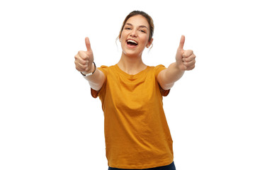 gesture and people concept - happy smiling young woman or teenage girl in orange t-shirt showing thumbs up over white background
