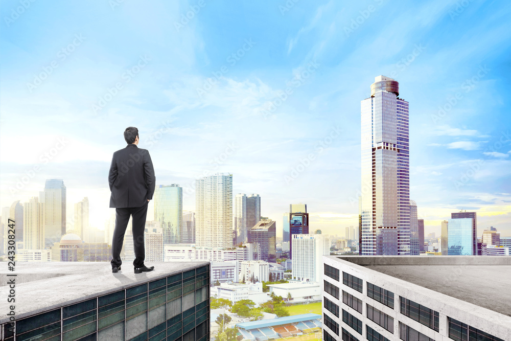 Rear view of asian businessman standing on the rooftop Rear view of asian businessman standing on the rooftop