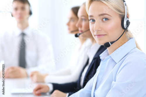 Call center. Group of operators at work. Focus at blonde business woman in headset © rogerphoto