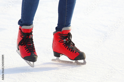 Female legs in skates on an ice rink