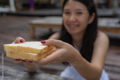 Young Asian woman holding sliced bread with feeling happy and good lifestyle. Selective focus.
