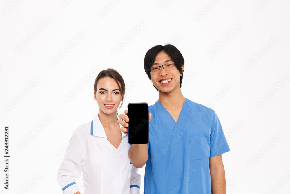 Smiling doctors couple wearing uniform standing Smiling doctors couple wearing uniform standing