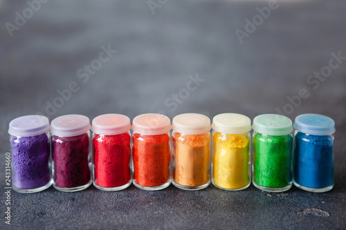 Foto Bright colourful powdered pigments in glass bottles for Indian holi festival on