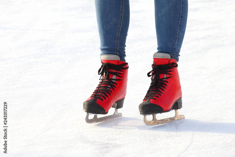 Female legs in skates on an ice rink Female legs in skates on an ice rink
