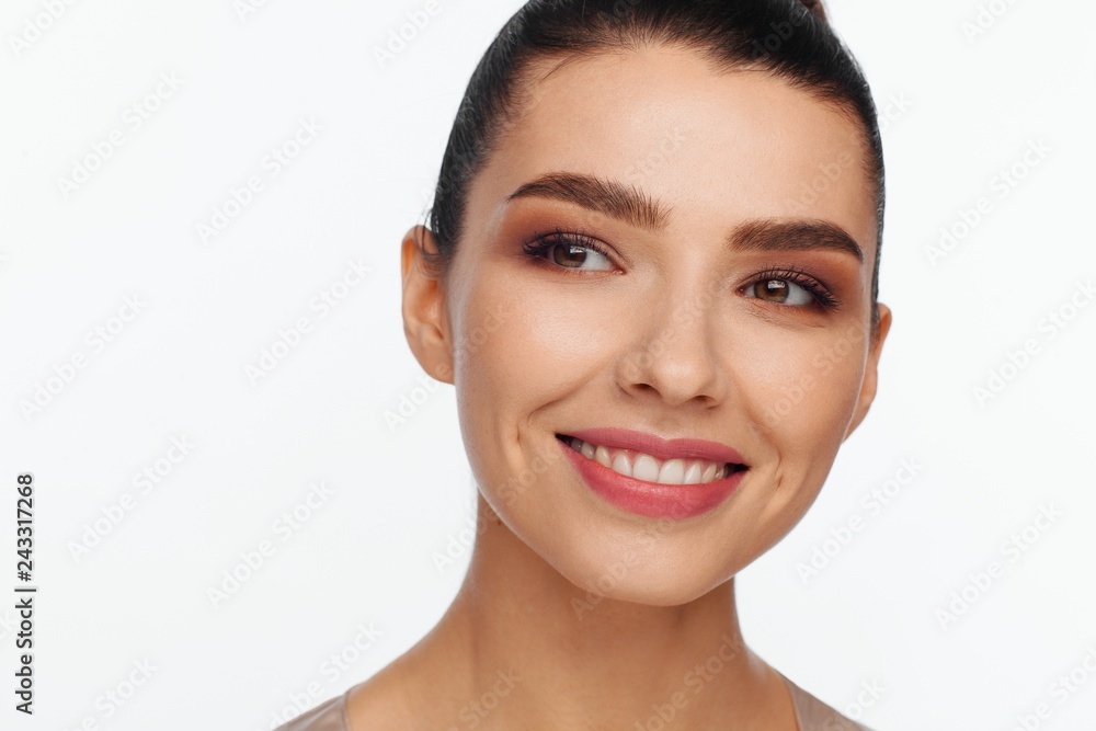 Obraz premium Portrait of a smiling beautiful woman with collected hair in the studio