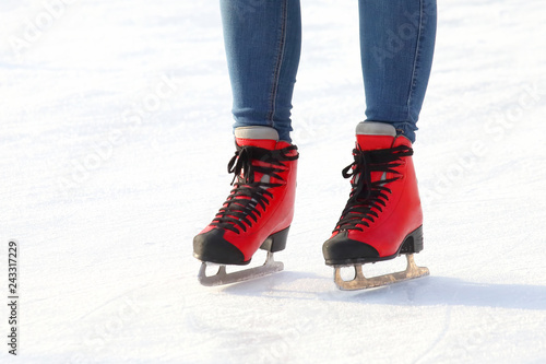 Female legs in skates on an ice rink