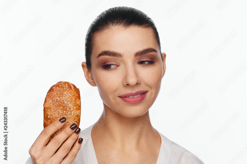 Portrait of a smiling beautiful woman with a sesame bun in her hand Portrait of a smiling beautiful woman with a sesame bun in her hand