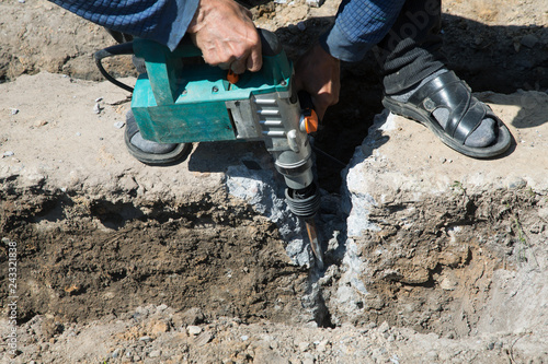 Worker hammer smashes the concrete foundation