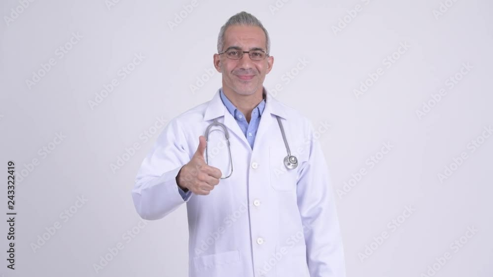 Happy Persian man doctor giving thumbs up against white background Happy Persian man doctor giving thumbs up against white background