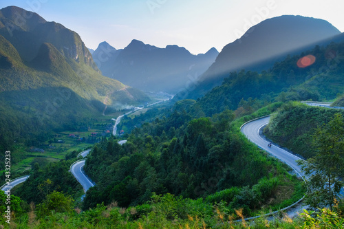 Motorbikers on winding roads through valleys and karst mountain scenery in the North Vietnamese region of Ha Giang / Dong Van.