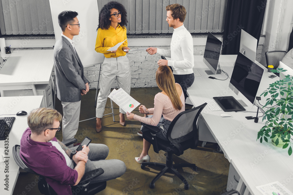 high angle view of multiracial young business people working together in office high angle view of multiracial young business people working together in office