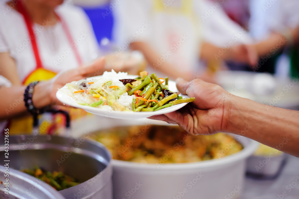 Hands of beggars accepting food from the hands of volunteers who come to help free food breaks.