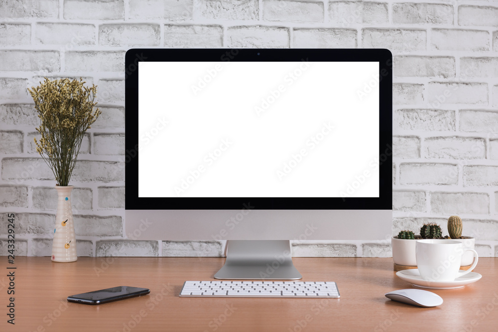 Blank screen of all in one computer with dry flowers, smart phone, coffee cup and cactus vase on white bricks background Blank screen of all in one computer with dry flowers, smart phone, coffee cup and cactus vase on white bricks background