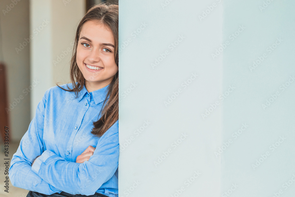 A modern business woman, standing, touched the gray wall. Young girl. A modern business woman, standing, touched the gray wall. Young girl.