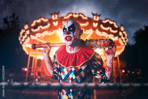 Obraz na płótnie Crazy clown with baseball bat in amusement park