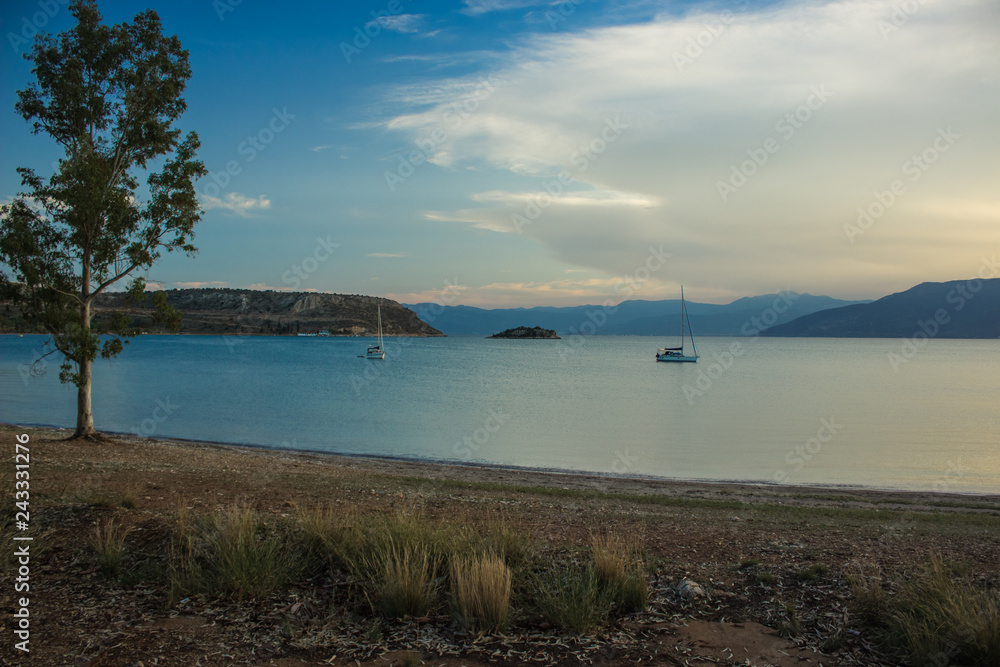 evening sea bay peaceful scenic landscape empty sand coast shoreline and fishing boats on calm water surface evening sea bay peaceful scenic landscape empty sand coast shoreline and fishing boats on calm water surface