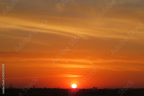 Beautiful fiery orange sunset background over the city, the sun sets over the horizon