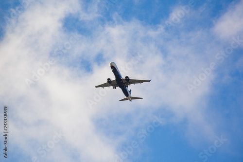 Passenger airplane landing against blue cloudy sky in Brazil