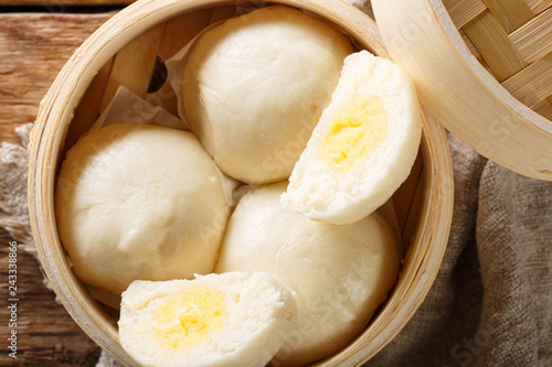 Chinese traditional steam custard buns closeup in bamboo steamer. horizontal top view