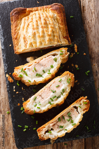 Traditional puff pastry pie stuffed with salmon with cheese close-up. Vertical top view photo