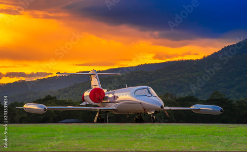 Fotografie Airplane model of Bombardier Learjet 35A parking on the apron with beautiful sunset and mountain Background