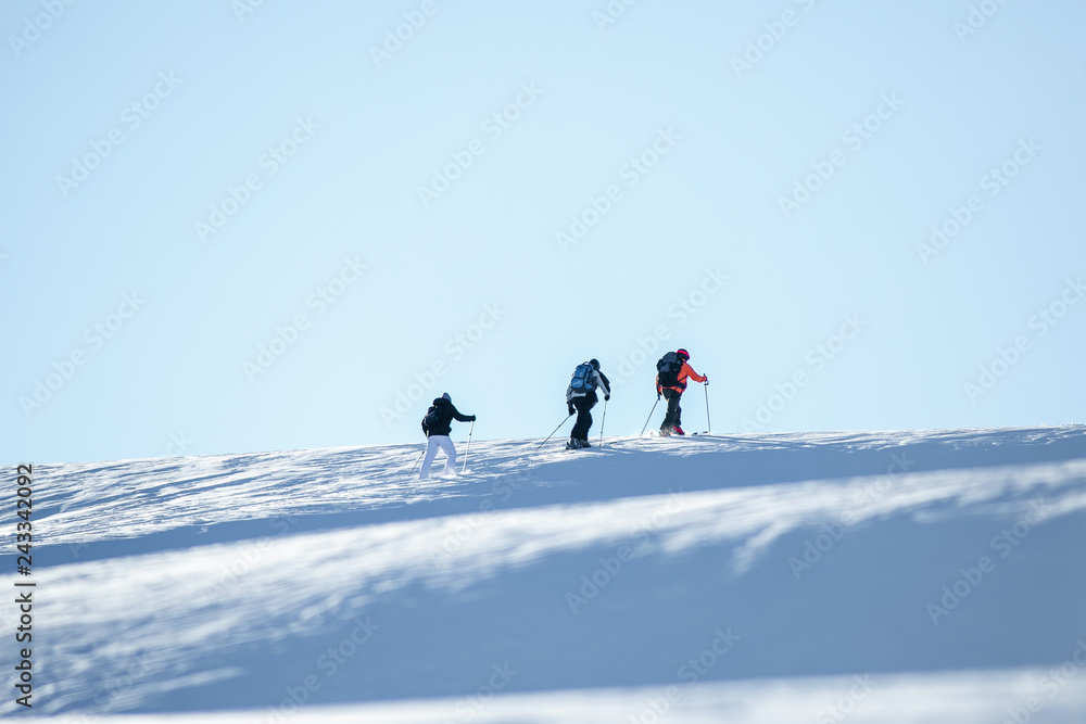 skiers go uphill, ski tour