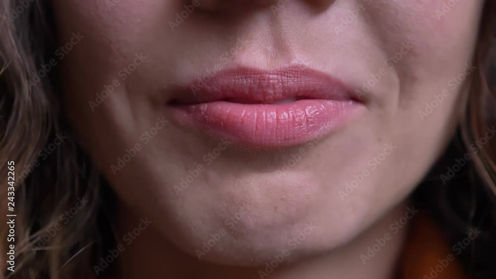 Closeup of sexy young caucasian female lips seductively moving and smiling Closeup of sexy young caucasian female lips seductively moving and smiling