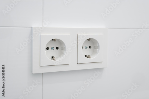 socket, electric plug on white tiles