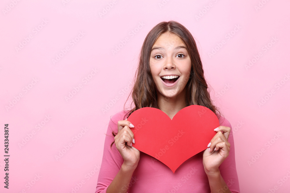 Young girl holding red paper heart on pink background Young girl holding red paper heart on pink background