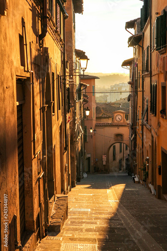 Fototapeta Naklejka Na Ścianę i Meble -  Romantic view to the narrow street in Tuscany, Italy at the sunset
