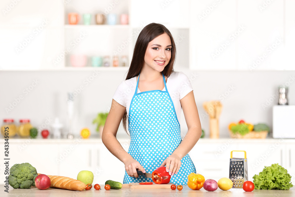 Beautiful woman cutting red pepper in the kitchen Beautiful woman cutting red pepper in the kitchen
