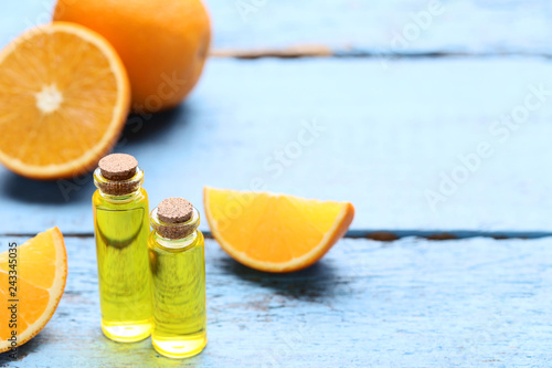 Orange oil in bottles on blue wooden table