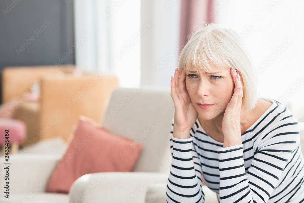 Fototapeta premium Woman suffering from headache, sitting at home