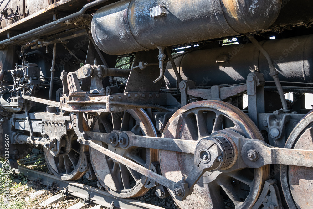 Old rusty wheels of the steam locomotive and the elements of the drive Old rusty wheels of the steam locomotive and the elements of the drive