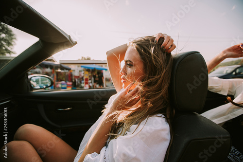 Young women driving in white cabriolet car and looking for freedom and fun © BGStock72