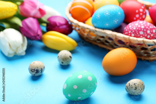 Easter and quail eggs with tulips on blue background