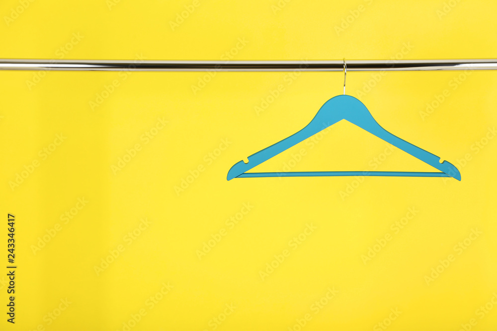 Wooden hanger hanging on yellow background