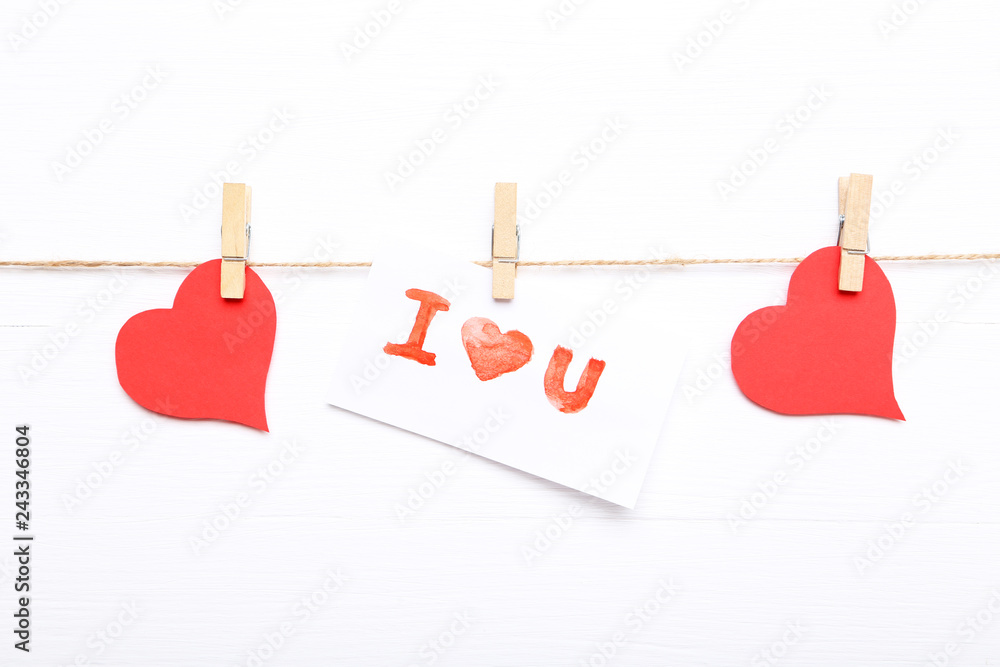 Paper with text I Love You hanging on white background Paper with text I Love You hanging on white background