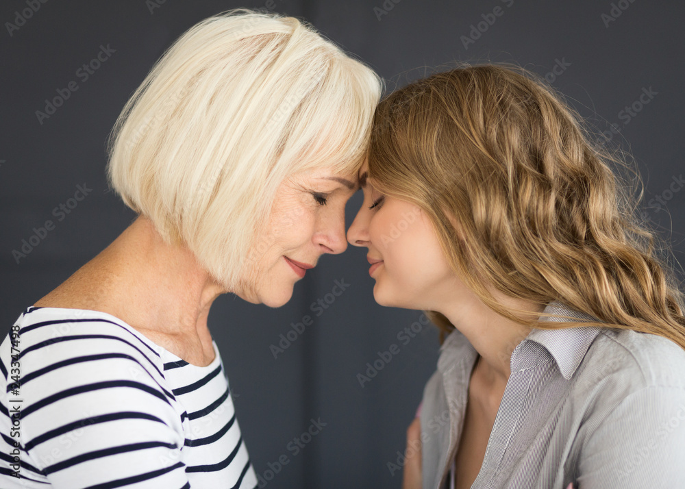 Senior mom and her daughter touching with foreheads Senior mom and her daughter touching with foreheads