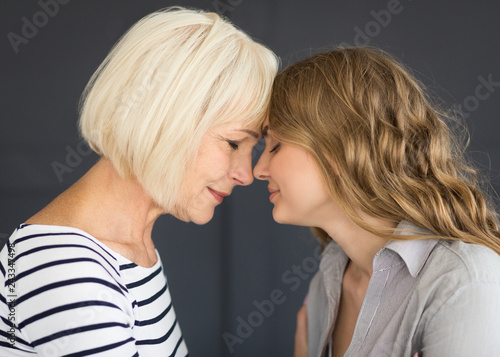 Senior mom and her daughter touching with foreheads