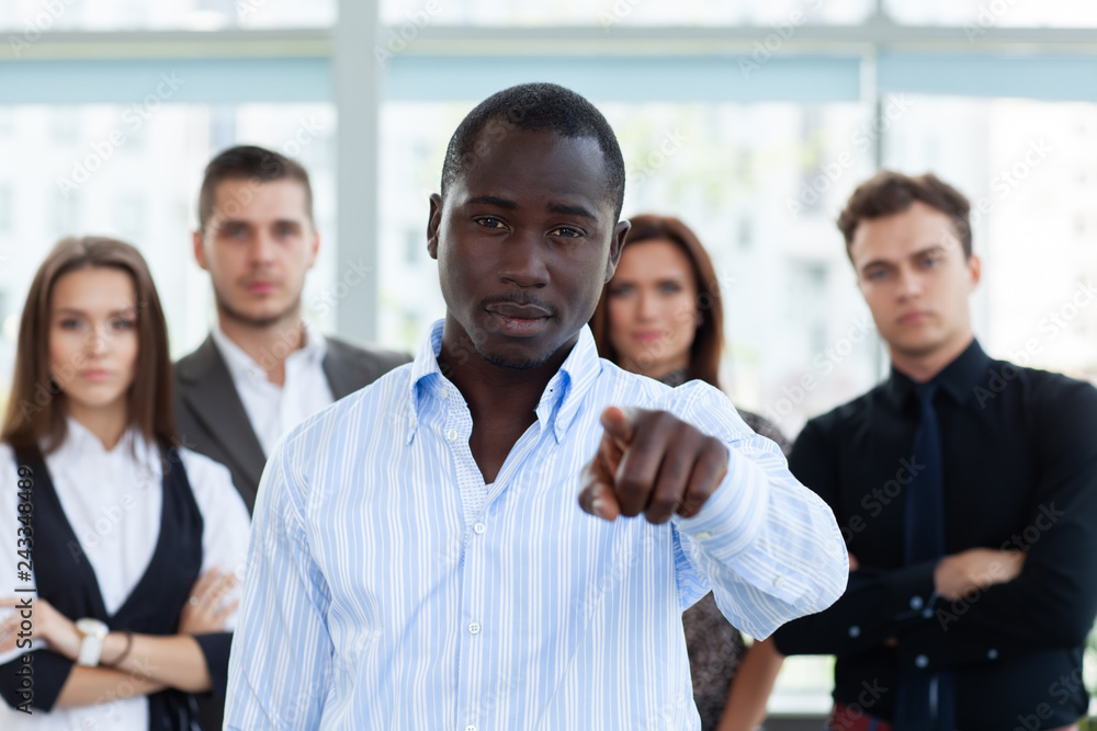 Obraz premium Handsome man pointing his finger at you on the background of business people.