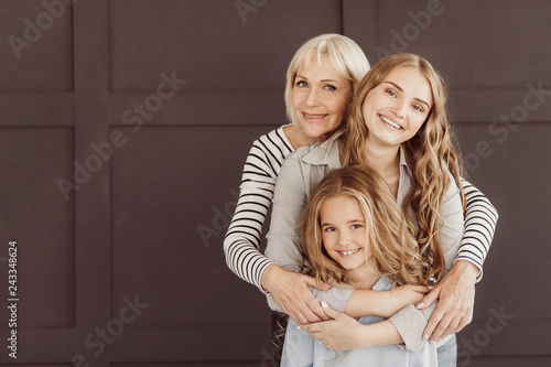 Three generations of happy women looking at camera