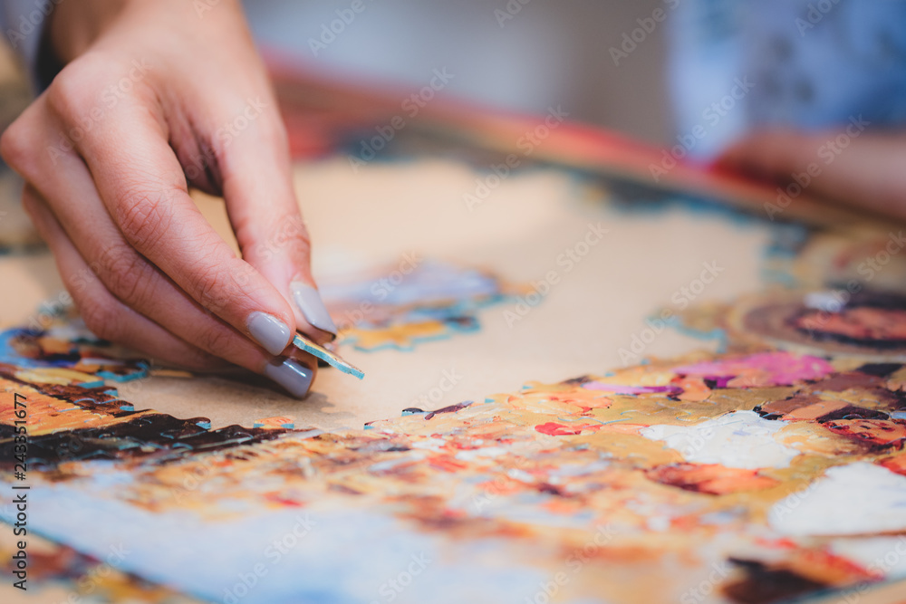 Fototapeta premium Adult and child solving a jigsaw puzzle on a table.