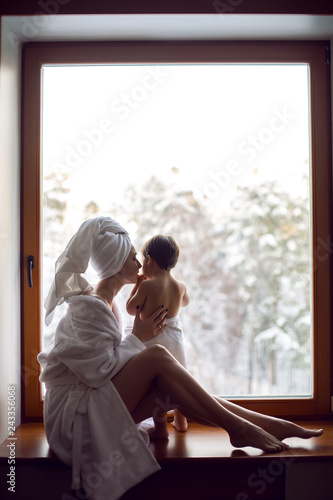 mom and son sitting by the window on a wide windowsill