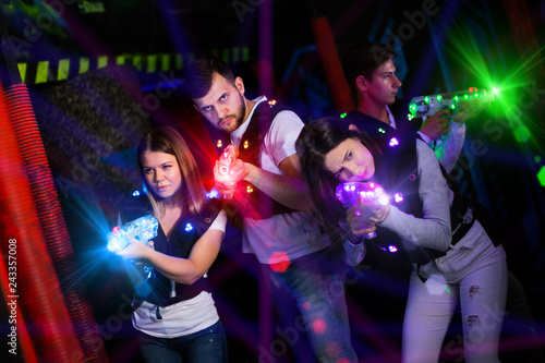 Young people playing laser tag in bright beams
