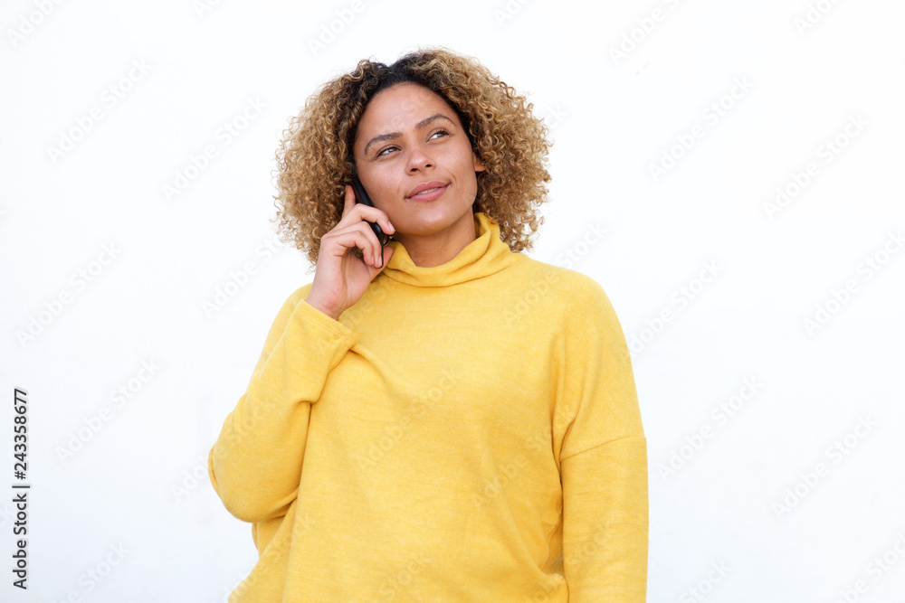 african american girl with curly hair talking on mobile and thinking phone by white background african american girl with curly hair talking on mobile and thinking phone by white background