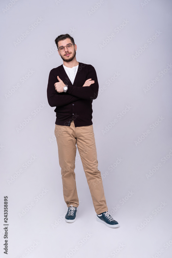 Full length portrait of a smiling casual man standing isolated on a gray background. Full length portrait of a smiling casual man standing isolated on a gray background.